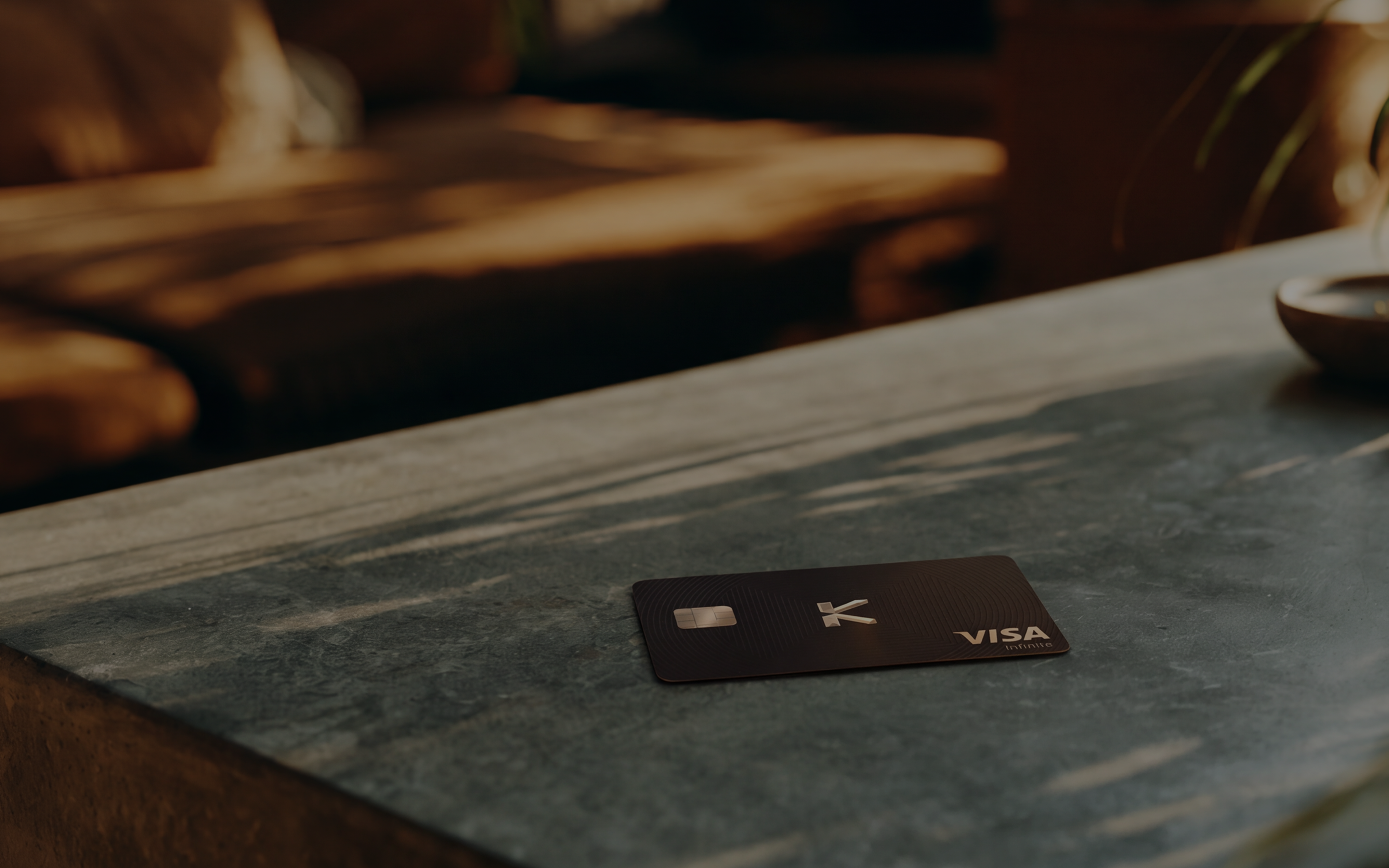 A KAST Visa Infinite card resting on a stone counter